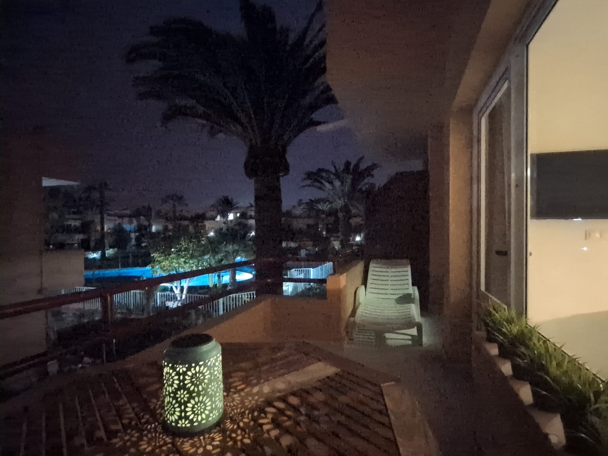 Terraza de noche con tumbona y piscina